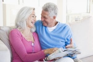 Mature Couple Looking at a Magazine and Smiling