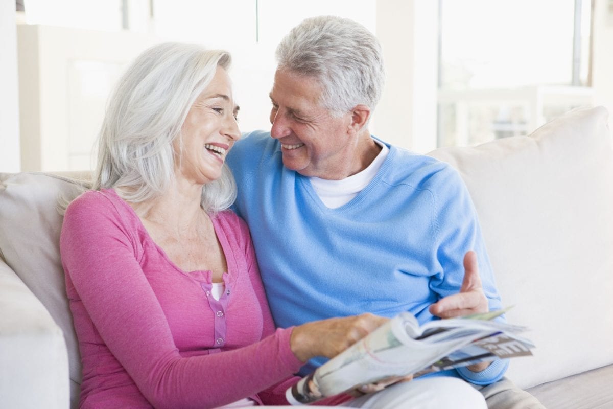 Mature Couple Looking at a Magazine and Smiling