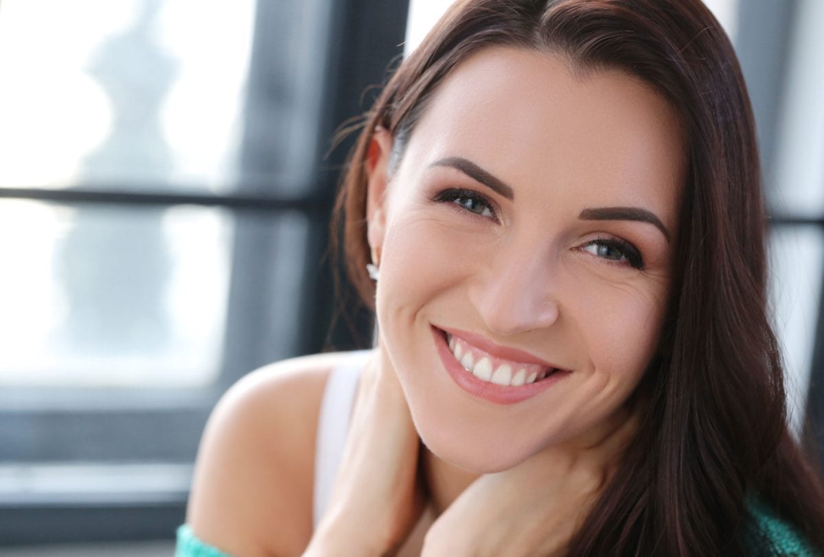Smiling Brunette Female With Hands Around Neck