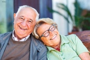 Old Couple Leaning Against Each Other on Couch