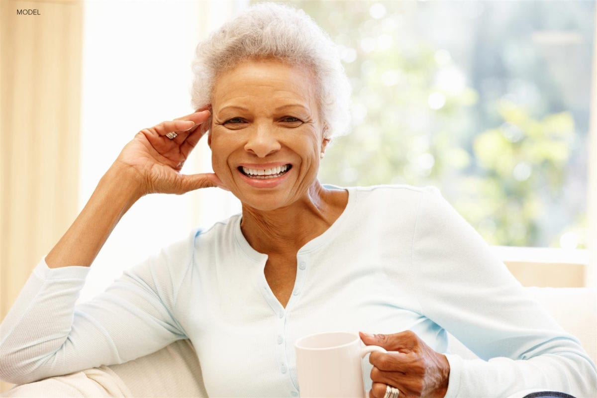 Mature Woman Smiling and Holding Mug While Sitting