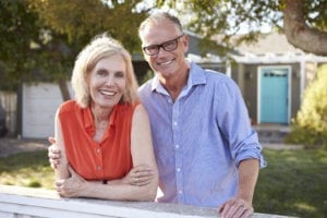 Portrait Of Mature Couple Looking Over Back Yard Fence