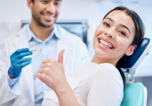 Shot of a happy woman giving the thumbs up in her dentists office